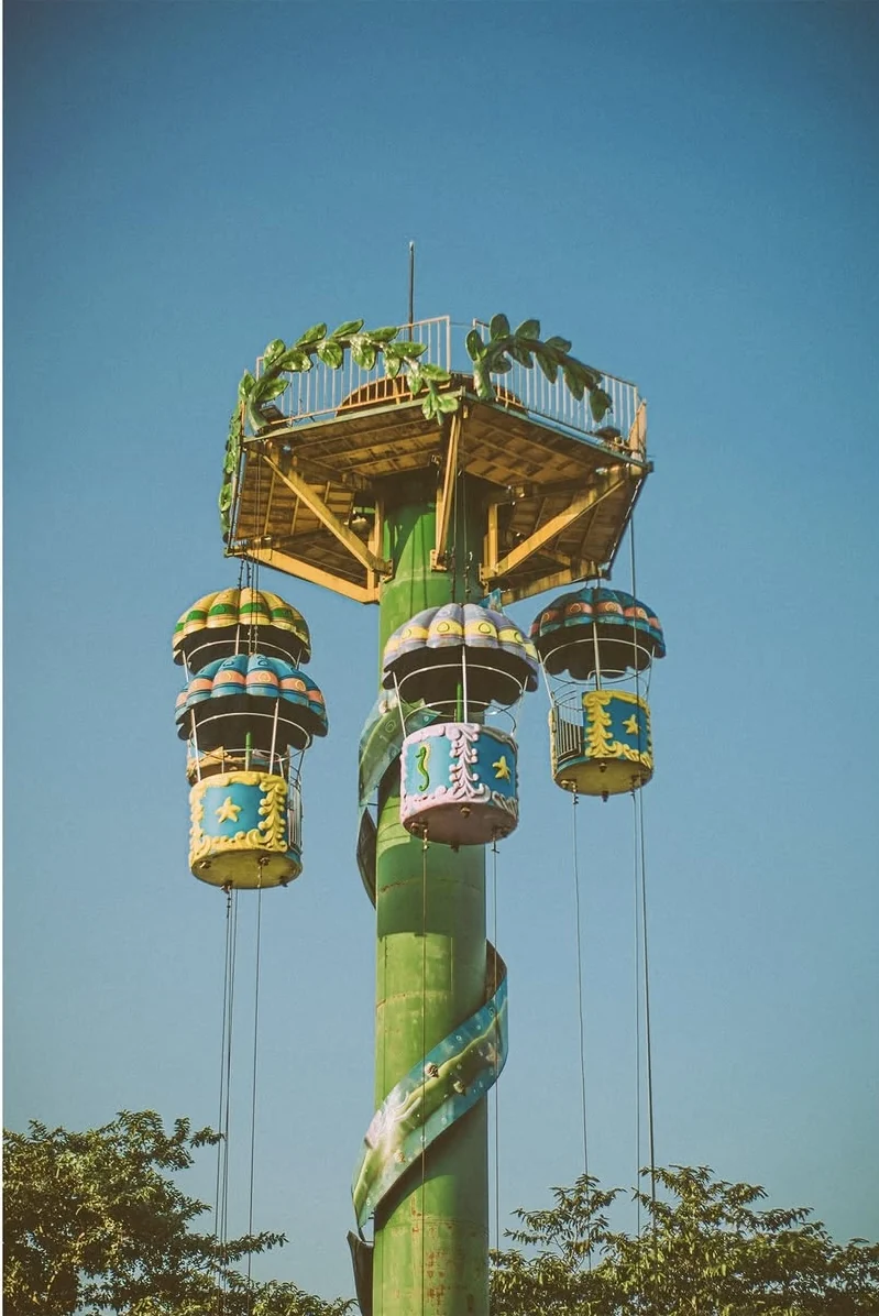 A parachute tower ride against a clear sky